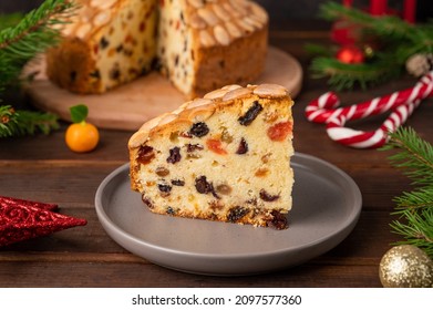 Traditional Christmas Dundee cake with dried fruits and almonds on a wooden board. Festive dessert. Rustic style, selective focus.
