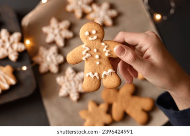 Traditional Christmas holiday dessert, gingerbread man cookie in hand of child, soft selective focus, lifestyle. - Shutterstock ID 2396424991
