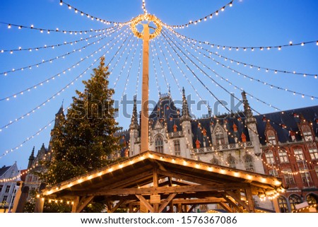 Traditional Christmas market in Europe, Bruges, Belgium. Main town square with decorated tree and lights. Christmas fair concept.