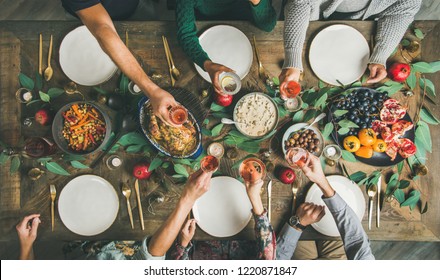 Traditional Christmas, New Year Holiday Celebration Party. Flat-lay Of Friends Or Family Feasting At Festive Table With Turkey Or Chicken, Roasted Vegetables, Mushroom Sauce And Fruit, Top View