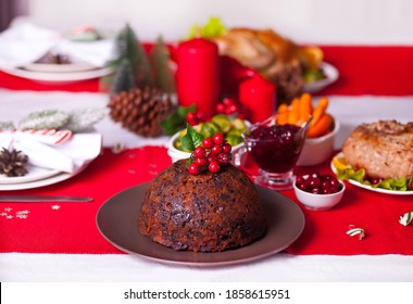 Traditional Christmas pudding with holly on top on a Christmas dinner