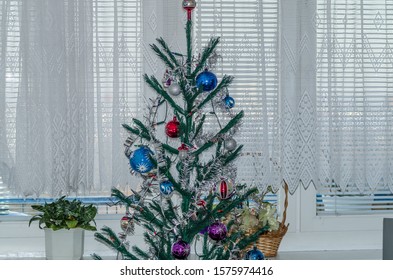 Traditional Christmas Tree Decorated With Various Decorations And Lights Full Frame Zoom On The Background Of White Curtains