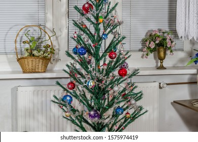 Traditional Christmas Tree Decorated With Various Decorations And Lights Zoom On Full Frame On The Background Of A White Window