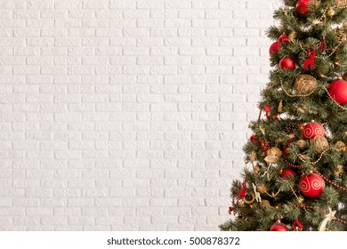 Traditional Christmas Tree On A White Brick Wall Background