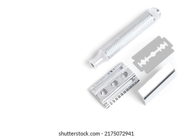 Traditional chrome-plated closed-comb safety razor disassembled on white background.