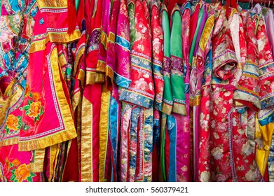 traditional colorful chinese robes on a hanging rail - Shutterstock ID 560379421