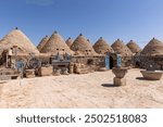 Traditional conical houses of Harran, Sanliurfa, Turkey. Traditional mud brick buildings topped with domed roofs and constructed from mud and salvaged brick.