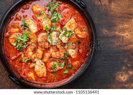 Traditional Creole cajun court bouillon with fish and seafood gumbo chowder stew as top view in a pot with copy space right
