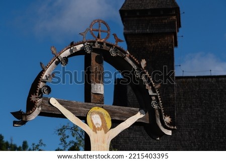 Traditional cross depicting Jesus with a wood church in the background in Maramures region of Romania. INRI refers to “Iesus Nazarenus, Rex Iudaeorum,” meaning “Jesus of Nazareth, King of the Jews.”