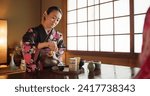 Traditional, culture and Japanese woman with tea in home with herbs, leaves and flavor in teapot. Kimono, indigenous and person with matcha beverage for ceremony, ritual and wellness for drinking