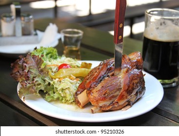 Traditional Czech pork knuckel on the bone speared with a knife