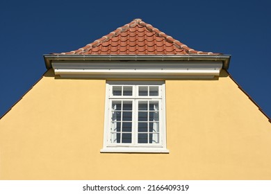 Traditional Danish House Facade In Ocher Yellow Against A Bright Blue Sky