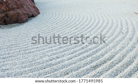 Traditional Details of Classical Japanese Zen Garden. Volcanic stones surrounded raked concentric lines gravel or sand. Symbolic imitation essence of nature in Japan. Gravel Rocks Garden. Meditation.