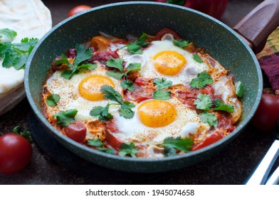 Traditional Dish Of Israeli Cuisine Shakshuka. Fried Eggs With Tomatoes, Peppers, Onions, Cilantro And Pita In A Pan