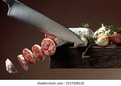 Traditional dry-cured sausage with thyme, onion, and garlic. Slices of flying dry-cured sausage in motion. Copy space.