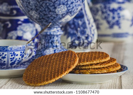 Traditional Dutch stroopwafel with syrup, cookie and tea, Delfts blue decorative crockery set on the table ,close-up, macro photo