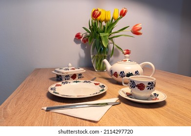 Traditional Dutch table set with tulips and hand-painted farmer's pattern ('boerenbont') on a wooden table.