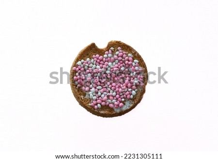 Traditional dutch treat eaten to celebrate the birth of a baby girl called beschuit met muisjes which consists of rusk with white and pink sugary anise seeds isolated on white background