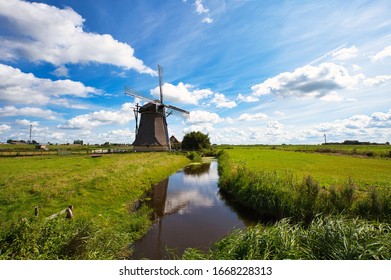 Traditional dutch windmill on a sunny summer day near a canal. Netherlands, Holland. 