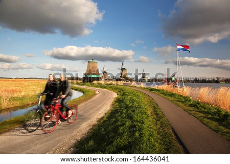 Traditional Dutch windmills with bikers near the Amsterdam in  Holland
