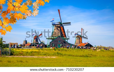 Traditional dutch windmills and houses near the canal in autumn, Zaanse Schans, Netherlands, Europe