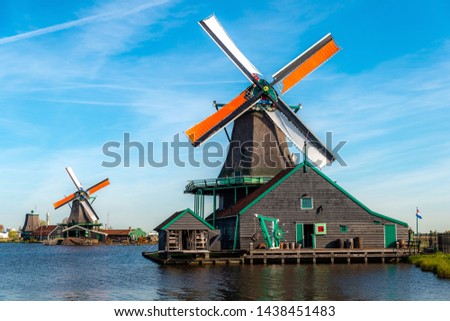 Traditional dutch windmills located by the river Zaan, in Zaanse Schans, Netherlands. Landscape and culture travel, or historical building and sightseeing concept