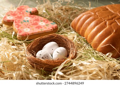 Traditional Easter bread with festive bunny cookie and decorative nest with eggs in rustic spring setting