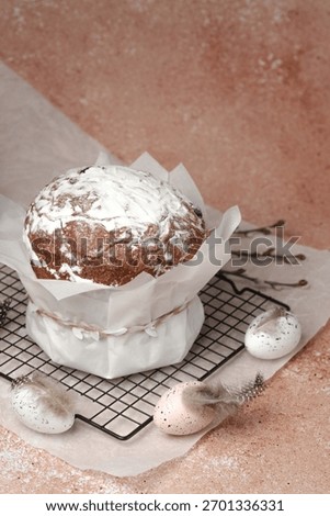 Traditional Easter cake with powdered sugar and speckled eggs on parchment paper. Festive food concept for spring holiday.