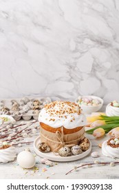 Traditional Easter Cake Or Sweet Bread, Quail Eggs, White Meringues In Shape Of Nest, Pussy Willow Twigs And Spring Flowers Over White Wooden Table. Side View, Copy Space. Easter Treat, Holiday Symbol