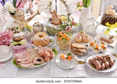traditional Easter dishes with white borscht, sausage, eggs, salad and cakes on festive table in Poland