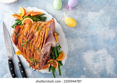 Traditional Easter ham spiral sliced with honey glaze stuffed with oranges and rosemary