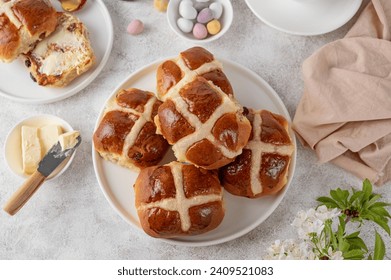 Traditional Easter hot cross buns on a white plate with butter, berry jam and cup of tea. Delicious Easter breakfast - Powered by Shutterstock