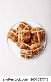 Traditional Easter treats cross buns with raisins on the white texture background. Top view