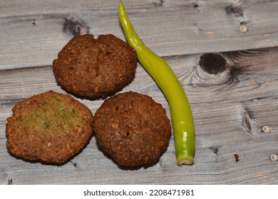 Traditional Egyptian Fried Falafel Balls, Green Burger, Made Of Ground Chickpeas And Broad Beans, Deep Fried Balls Or Patty-shaped Fritter With Chili Green Fresh Pepper Isolated On Wood Background