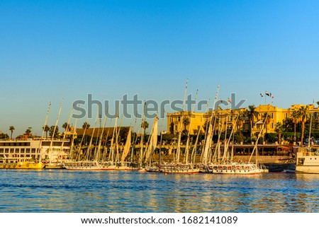 Traditional egyptian vessels feluccas and tourist boats moored near bank of Nile river in Luxor, Egypt