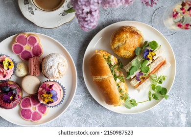 Traditional english afternoon tea with selection of cakes and sandwiches - Shutterstock ID 2150987523