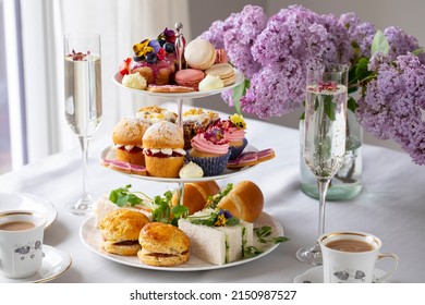 Traditional english afternoon tea with selection of cakes and sandwiches - Shutterstock ID 2150987527