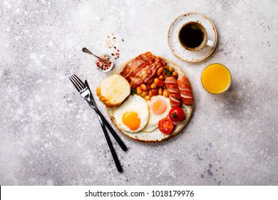 Traditional English Breakfast Food on stone Eggs ,Sausages, Bacon, Beans,Toasts,Coffe and Orange juice Top View - Shutterstock ID 1018179976