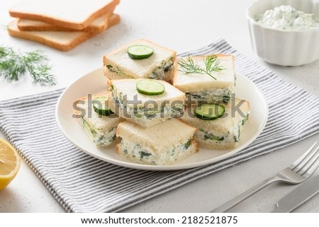 Traditional English tea cucumber sandwiches with cream cheese and dill on white background. Close up.