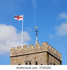 Traditional English Village Church Tower with Flag of St. George and golden weather-vain