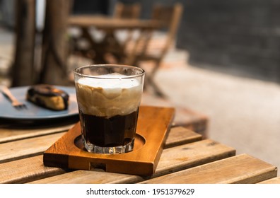 Traditional espresso coffee with white foamy cream cup on wood table, homemade cold mixed coffee 