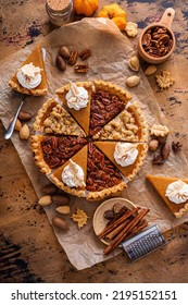 Traditional Fall Thanksgiving Pies Variety Of Slices Arranged Into Circle, Pumpkin Crumb And Pecan Pie Overhead On A Rustic Wooden Table