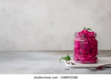 traditional fermented cabbage with beets in a jar. vegetarian food concept. banner, gray background