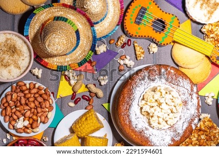 Traditional Festa Junina Summer Festival Carnival Food. Traditional Brazilian Festa Junina dishes and snacks - popcorn, peanuts, corn cake,beans, cookie, pacoca, with holiday decor and accessories