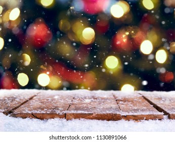 Traditional festive Christmas tree light decoration background with a snow covered wooden table top. - Powered by Shutterstock