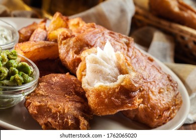 Traditional fish in beer batter and chips with green pea and tartar sauce