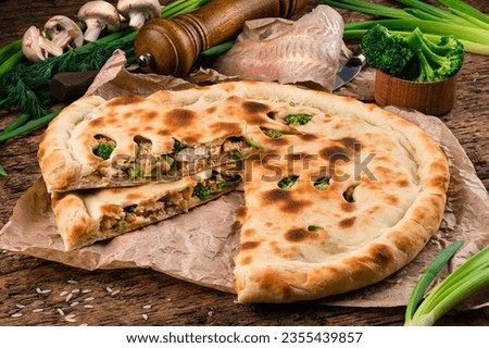 Traditional fish closed pie on the table. Sliced closed pie with white fish, broccoli, greens and spices. Stock photo © 
