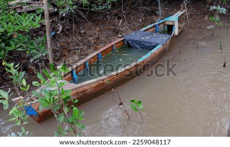 A Traditional Fishing Canoe That Is Worn Out And Damaged By River Water, In The Village Of Belo Laut During The Day