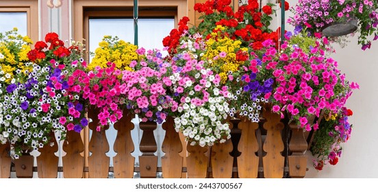 Traditional flowered balcony at the Alps and Dolomites. Colorful flowers on balcony. Summer time. Mix of flowers and colors. General contest of the European Alps - Powered by Shutterstock