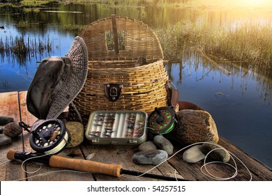 Traditional fly-fishing rod with equipment beside a lake late afternoon